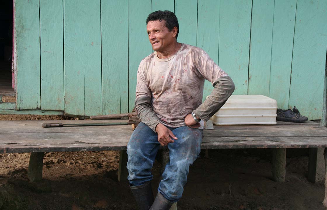 Farmer seated on bench in work clothes, NetZero project
