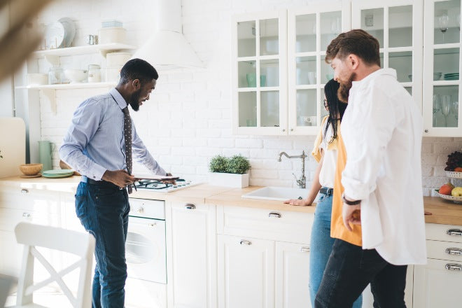 Estate agent showing kitchen to young couple