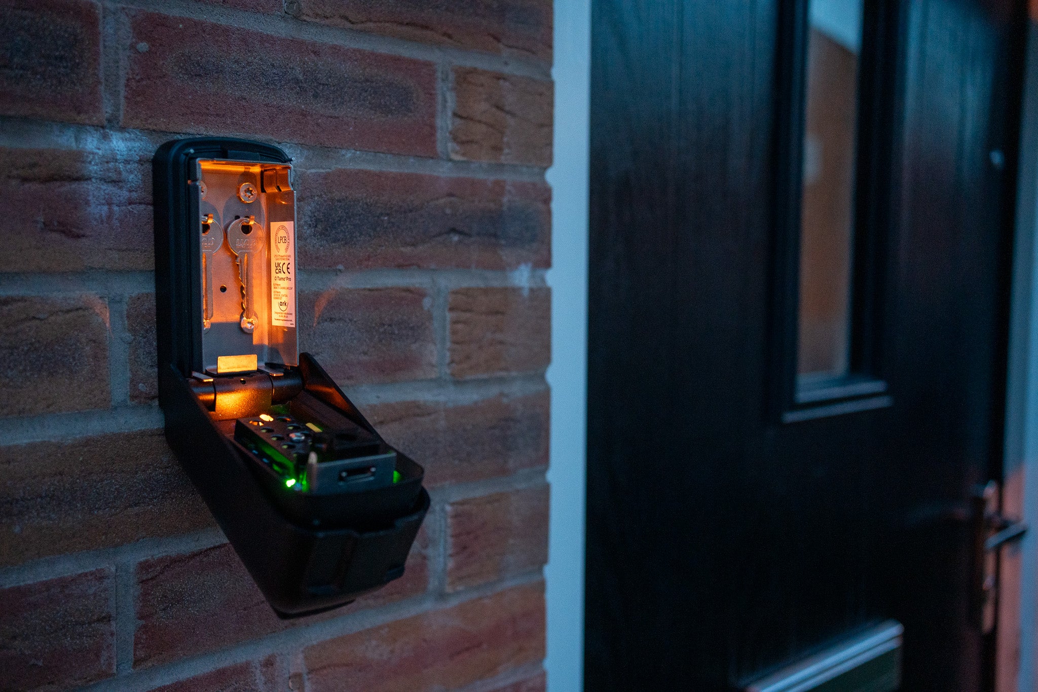 Tamo Pro Key safe on the front of a house at night with the lights on and keys showing