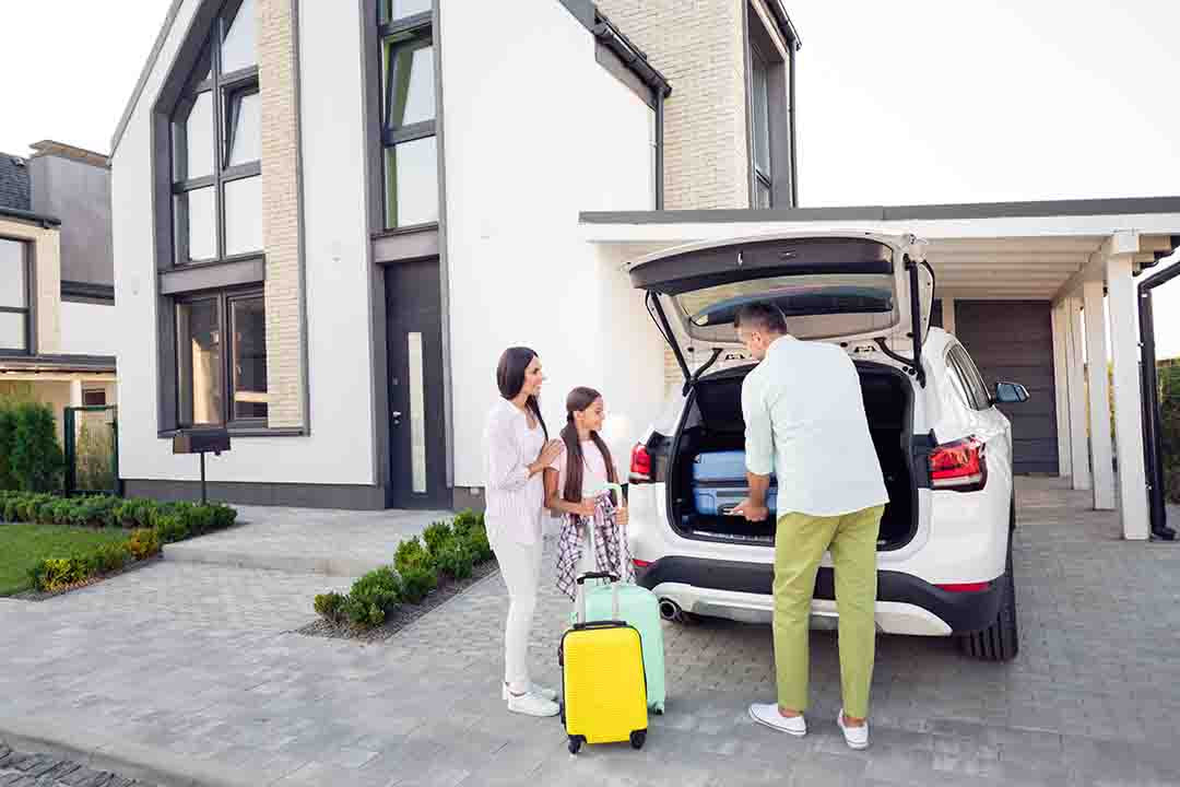 Family of three unloading the car at their holiday home in the UK