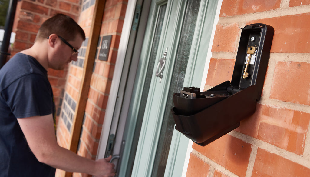 Man opening door next to unlocked Mechanical Key Safe holding keys ark Tamo