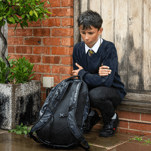 School boy locked outside in the rain