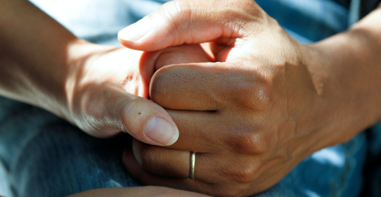 Close up of hands holding each other
