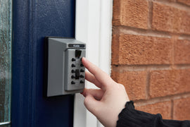 Supra J5 over the door key safe attached to front door with lady putting in her code