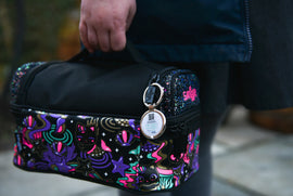Digital keyring saying 'i'm lost' attached to colourful travel bag